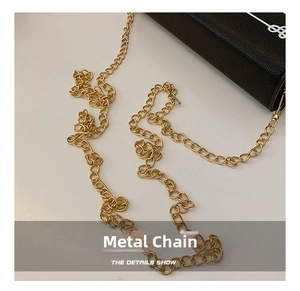 Close-up of premium gold metal chain strap on black lychee grain leather crossbody bag