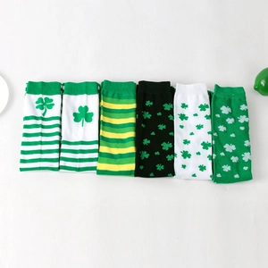 Flat lay of six pairs of green St. Patrick's Day socks with clover and stripe patterns