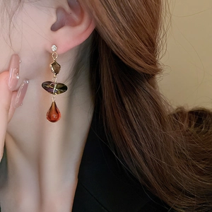 Primo piano di una modella con orecchini pendenti vintage con ambra e pietre di cristallo