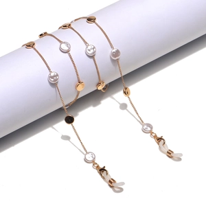 Golden pearl eyewear chain with metal discs and silicone loops on a white background