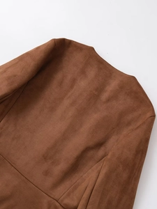 Detailaufnahme der braunen Wildlederjacke zeigt Stoffstruktur und Kragennähte im Detail
