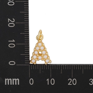 Detailed size measurement of a gold letter A pendant with pearls on a millimeter scale