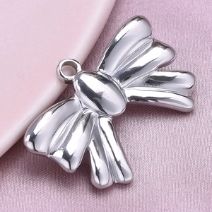 Macro detail of silver stainless steel bow pendant showing high polish finish and loop