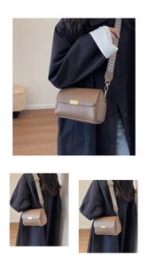 Détail du sac en cuir marron grainé avec une large bandoulière au motif ethnique