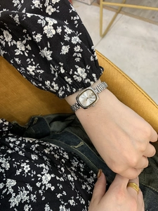 Silver bracelet-style ladies' watch featuring a small square dial on a model's wrist