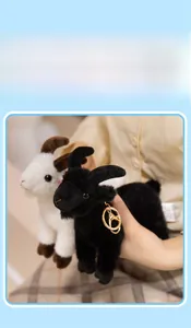 Close-up of black and white plush goat charms with golden metal ring keychains