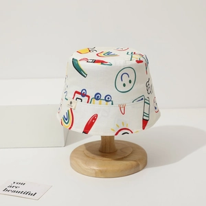 Detail of baby sun hat with colorful cartoon graffiti prints and logo tag on wood stand
