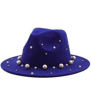 Close-up of royal blue wool jazz hat with white pearls and gold bead decorations