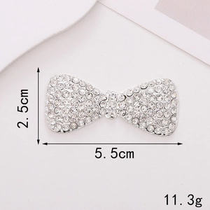 Detailed view of silver bow charm with sparkling rhinestones, size 5.5cm x 2.5cm