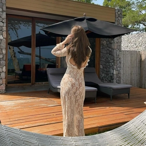 Back view of lace long sleeve sheer maxi dress featuring U-neck and open back detail