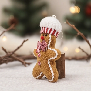 Gingerbread man plush ornament with chef hat and red stripes in cozy Christmas setting