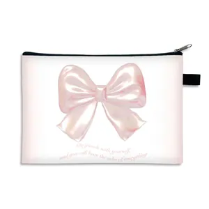 Minimalist white cosmetic bag featuring a pink bow and zipper for travel storage