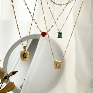 Golden titanium steel necklaces featuring heart, emerald, and black gemstone pendants