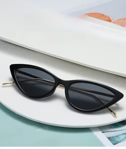 Detail view of retro cat-eye sunglasses with black frames and slim gold metal temples