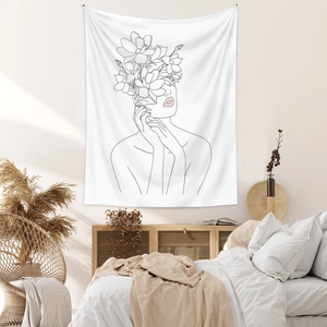 Detail of minimalist line art wall tapestry featuring floral female figure in bedroom
