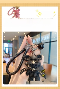Detailed view of resin bear keychain with knitted texture and woven wrist strap