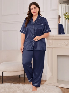 Detail of navy blue silk satin pajama set with contrast piping on shirt and pants