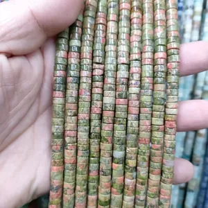 Close-up of natural unakite stone cylinder beads showing green and pink mineral texture