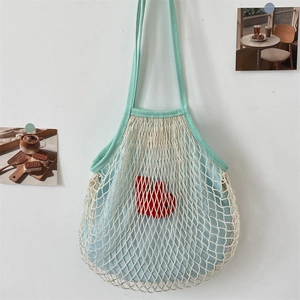 Detail der mintgrünen Griffe und cremefarbenen Netztasche mit hellblauem Innenbeutel
