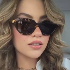 Retro tortoise shell cat eye sunglasses with gold hinge detail shown on model