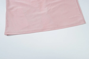 Dettaglio ravvicinato della doppia cucitura sull'orlo del vestito rosa elegante