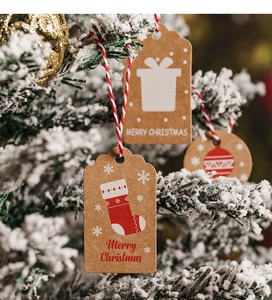 Close-up of brown kraft paper Christmas tags with festive gift and stocking illustrations