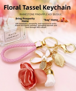 Detail of floral tassel keychain with pink woven strap and white enamel flower