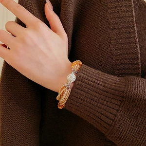 Vue détaillée d'un bracelet multicouche en perles d'ambre avec breloque en pavé d'argent
