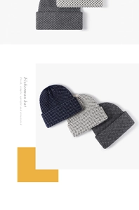 Texture de maille détaillée des bonnets de pêcheur structurés en bleu marine, beige et gris