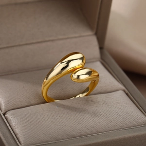 Anillo abierto dorado minimalista con extremos pulidos sobre forro de satén
