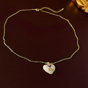 Detailed shot of golden heart pendant necklace with zircon inlay on leather texture