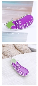 Detailed view of a purple eggplant enamel pin with No thanks text on white canvas