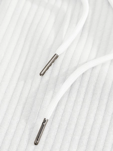 Detail of white corduroy fabric texture and drawstring with silver metal tips
