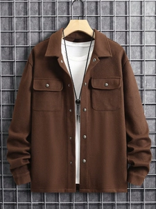 Close-up of brown corduroy worker jacket with chest pockets and metal buttons