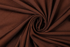 Detail von kaffeebraunem Rippstrick mit weicher Spiralraffung und elastischer Textur