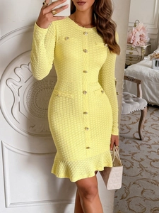 Detail view of yellow knit dress featuring gold buttons and ruffle hem in an elegant setting