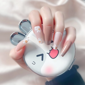 Long nude pink and brown press-on nails with daisy patterns and glitter finish