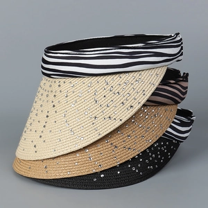 Detail view of woven sun visors featuring zebra patterns and sparkling rhinestone embellishments