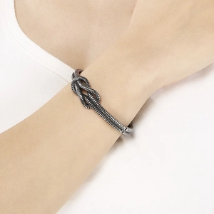 Close-up of retro knotted metal cuff bracelet with oxidized silver finish on wrist