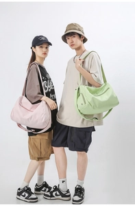 Détail du sac de sport vert clair avec poche zippée latérale et bandoulière réglable