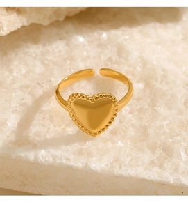 Macro shot of 18K gold plated heart ring on white mineral stone background