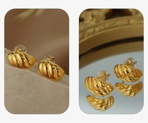 Macro shot of gold croissant-style earrings with spiral texture and silicone backings