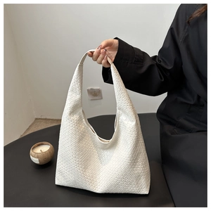 Close-up of the intricate woven texture and high-quality leather on this white tote bag
