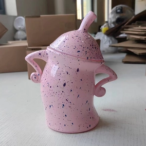 Pink ceramic canister with blue spots and curved handles in a cartoon character design