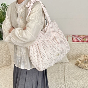 Nahaufnahme der rosa gepunkteten Canvas-Tasche mit Rüschen und Schleife am Trageriemen