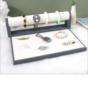 Gray and white jewelry display tray with a detachable watch bar in a modern setting