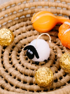 Pendentif mouton en peluche blanc moelleux dans un panier avec décor de récolte d'automne