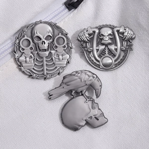 Gothic punk silver skull brooches featuring crow and motorcycle motifs on grey canvas