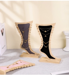 Detail of wooden foot-shaped jewelry display stand with velvet lining and side slots