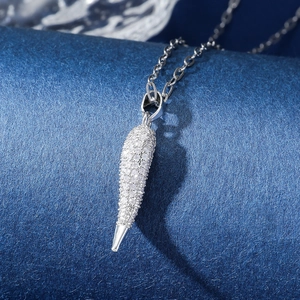 Macro view of silver necklace featuring a tapered pendant fully set with white zircons